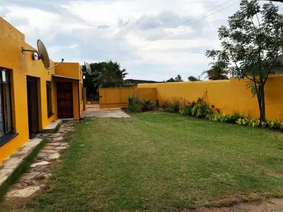 an empty yard next to a yellow building at Bobirwa Resort & Accomodation in Polokwane