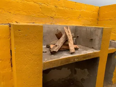 a yellow wall with a shelf with two pieces of wood at Bobirwa Resort & Accomodation in Polokwane