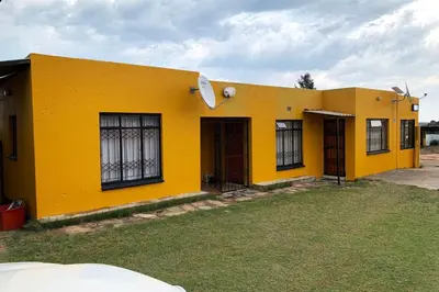a yellow building with a door and windows at Bobirwa Resort & Accomodation in Polokwane