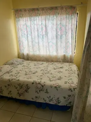 a bedroom with a bed with a window with flowers at Bobirwa Resort & Accomodation in Polokwane