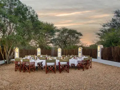 a table set up for a meal in a backyard at Kubu Safari Lodge in Hoedspruit