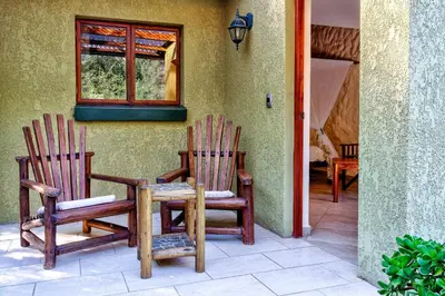 two chairs sitting outside of a house with a window at Kubu Safari Lodge in Hoedspruit