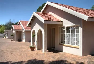 a row of houses on a brick street at Plumtree Lodge in Polokwane