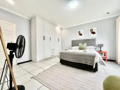 a white bedroom with a bed and a tripod at Comfort in Glen Austin, Midrand in Midrand