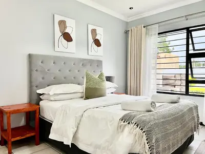 a white bedroom with a large bed and a window at Comfort in Glen Austin, Midrand in Midrand