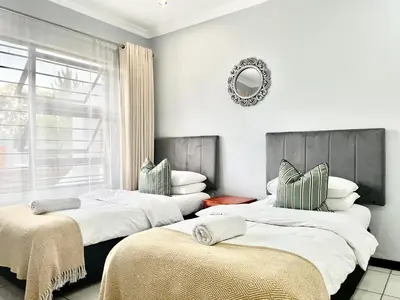 two beds in a room with a window at Comfort in Glen Austin, Midrand in Midrand