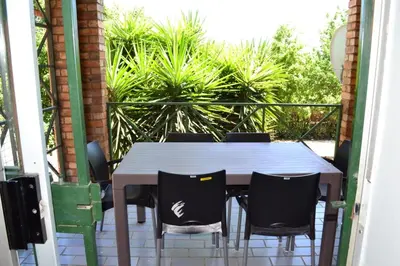 a table and chairs on a balcony with plants at Soldout Camp 2 in Pretoria