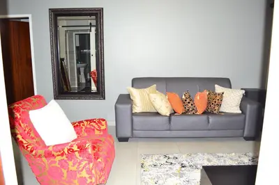 a living room with a couch and a chair at Soldout Camp 2 in Pretoria