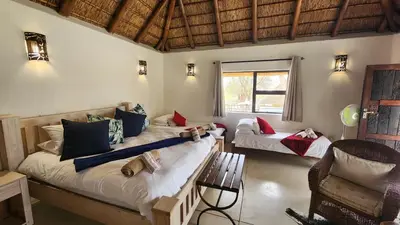 a room with two beds and a chair in it at Heartland Self-catering Accommodation in Kampersrus AH