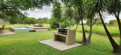 a garden with a bench and a swimming pool at Heartland Self-catering Accommodation in Kampersrus AH