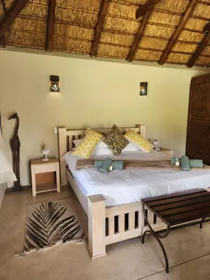 a bedroom with a bed and a bench in a room at Heartland Self-catering Accommodation in Kampersrus AH
