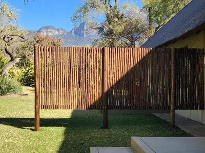 a wooden fence in a yard with mountains in the background at Heartland Self-catering Accommodation in Kampersrus AH