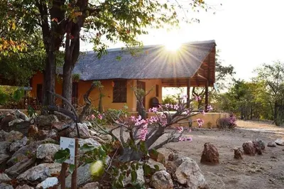 a house with the sun shining on the roof at Bushvilla's Silonque in Phalaborwa
