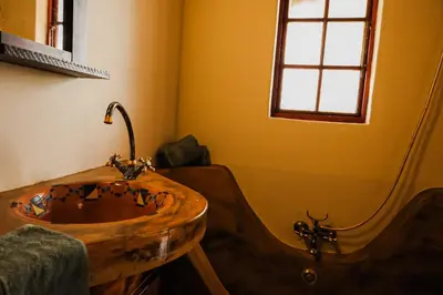 a bathroom with a wooden sink and a tub at Bushvilla's Silonque in Phalaborwa