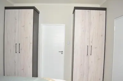 two wooden doors in a room with a bed at Soldout Camp 1 in Johannesburg