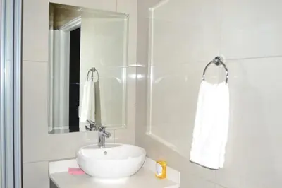 a white bathroom with a sink and a mirror at Soldout Camp 1 in Johannesburg