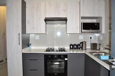 a white kitchen with a stove and a microwave at Soldout Camp 1 in Johannesburg