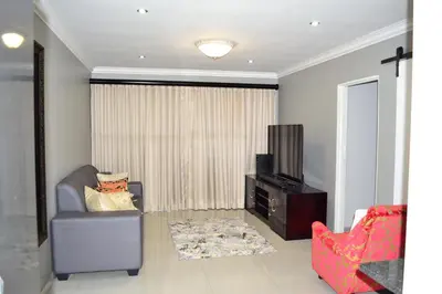 a living room with a tv and a chair at Soldout Camp 1 in Johannesburg