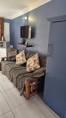 a living room with a couch and a blue wall at 44 on Ennis Guest Lodge and Restaurant - in Ermelo