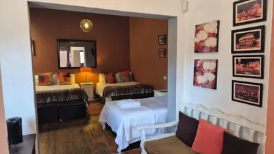 a hotel room with two beds and a mirror at 44 on Ennis Guest Lodge and Restaurant - in Ermelo