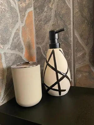 a black and white soap dispenser sitting on a table at Betel in White River