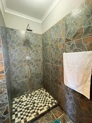 a bathroom with a shower with a checkered floor at Betel in White River