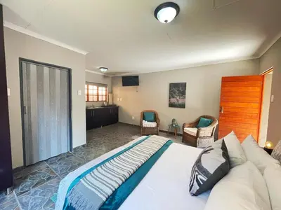 a bedroom with a large bed and two chairs at Betel in White River