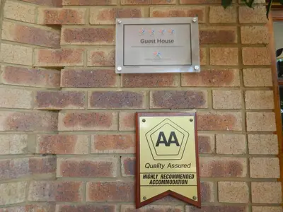 a sign for a guest house on a brick wall at Edelweiss Corporate Guest House in Pretoria