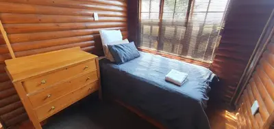 a bedroom with a bed and a dresser in a room at Amafu Forest Lodge in Hoedspruit
