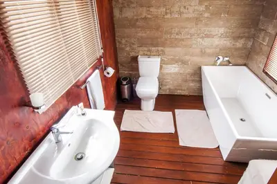 a bathroom with a sink and a tub and a toilet at Amafu Forest Lodge in Hoedspruit