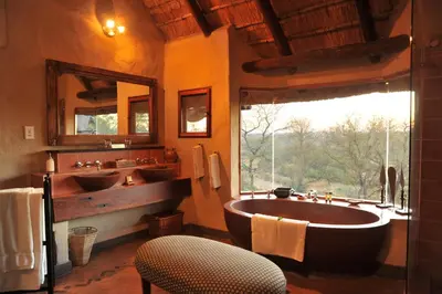 a bathroom with two sinks and a large tub at Lukimbi Safari Lodge in Malelane