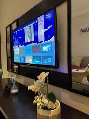 a tv on a wall in a room with a table at Thorntree Self Catering Apartment, Witbank in Witbank