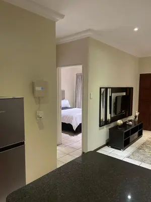 a living room with a television and a bed at Thorntree Self Catering Apartment, Witbank in Witbank