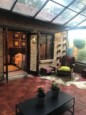 a room with a patio with a bed and a table at Kyasaja Home away from home in Pretoria
