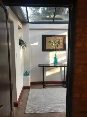 a room with a table with a vase on it at Kyasaja Home away from home in Pretoria