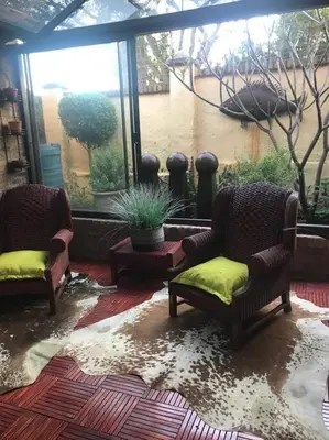 a living room with two chairs and a window at Kyasaja Home away from home in Pretoria
