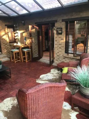 a living room with two couches and a brick wall at Kyasaja Home away from home in Pretoria