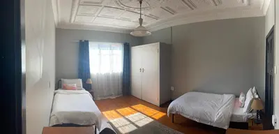 a bedroom with two beds and a window at Smartshelter Richard in Pretoria