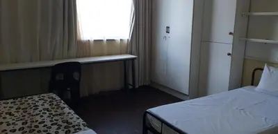 a bedroom with a bed and a desk and a window at 4-Bedroom Apartment in Pretoria
