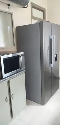 a microwave on a counter next to a refrigerator at 4-Bedroom Apartment in Pretoria