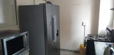 a stainless steel refrigerator in a kitchen next to a stove at 4-Bedroom Apartment in Pretoria
