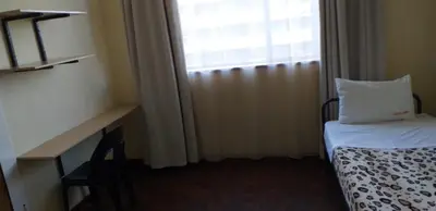 a room with a bed with a pillow and a window at 4-Bedroom Apartment in Pretoria