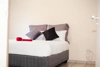 a bed with many pillows on top of it at Marelden security estate in Witbank