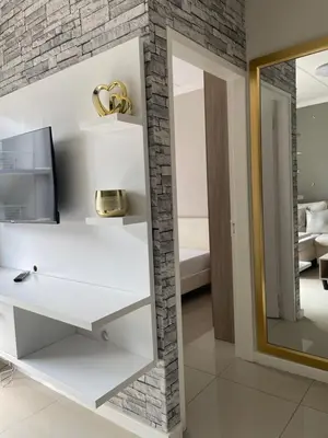 a living room with a mirror and a white shelf at Classy 2 bedroom in Halfway Gardens in Midrand