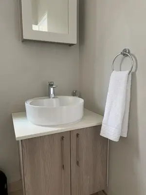 a bathroom with a white sink and a mirror at Classy 2 bedroom in Halfway Gardens in Midrand