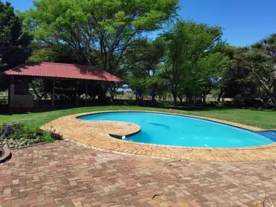 a swimming pool with a brick path around it at Lunford Garden Cottage in Rayton