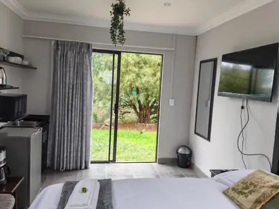 a bedroom with a bed and a sliding glass door at Lunford Garden Cottage in Rayton