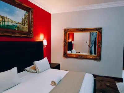 a bedroom with a bed and a mirror on the wall at Red Apple Guest House in Pretoria