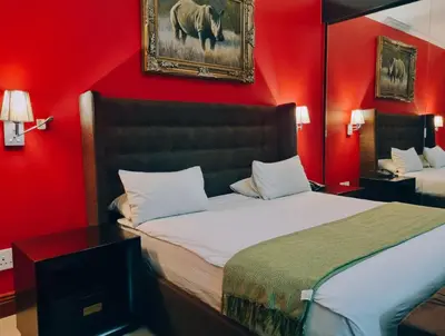 a red bedroom with a bed and a picture of a rhino at Red Apple Guest House in Pretoria
