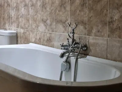 a white bath tub in a bathroom with a toilet at Red Apple Guest House in Pretoria
